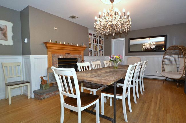 Dining space featuring visible vents, a chandelier, wood finished floors, built in features, and wainscoting | Image 5