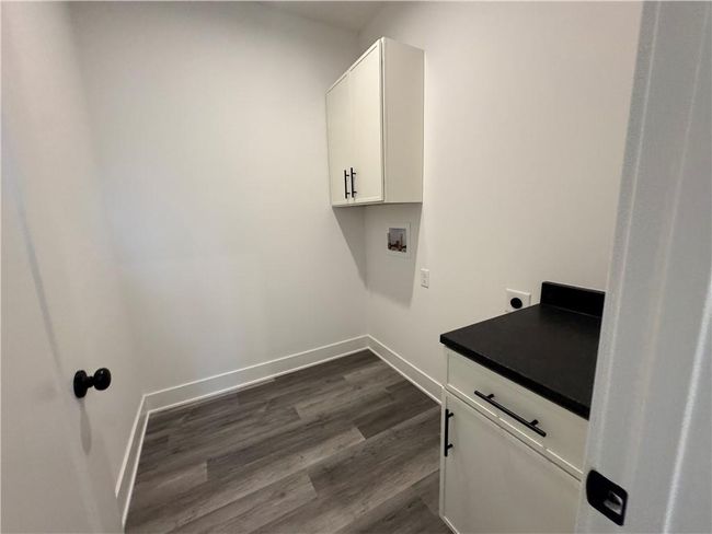 Laundry room with hookup for a washing machine, baseboards, hookup for an electric dryer, cabinet space, and dark wood-style floors | Image 35