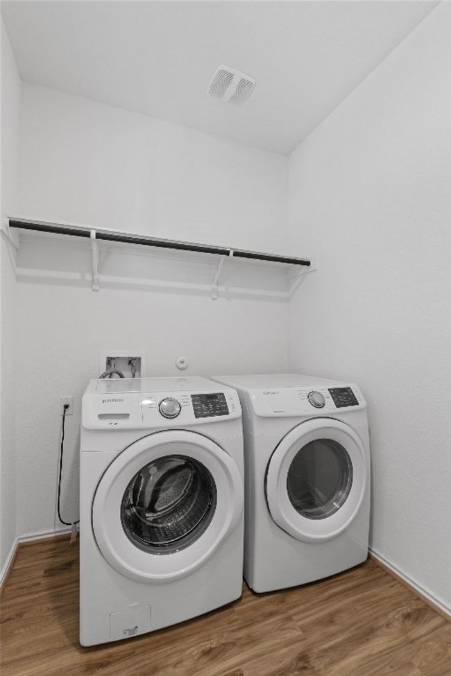 Clothes washing area with washer and dryer, laundry area, visible vents, and wood finished floors | Image 18