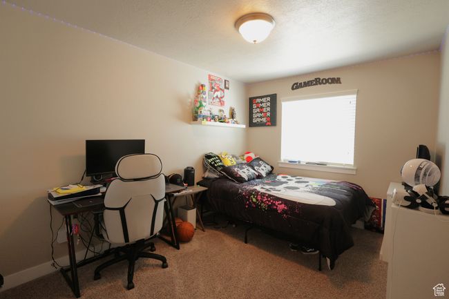 Bedroom with light colored carpet and an office area | Image 8