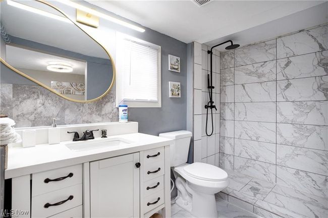 Full bathroom with a tile shower, marble finish floor, vanity, and toilet | Image 11