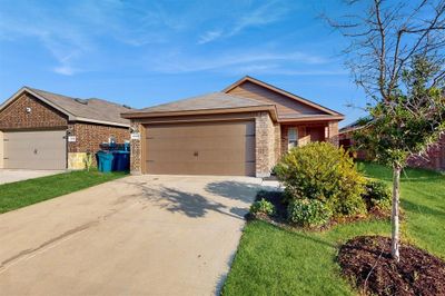 Ranch-style home with a garage and a front lawn | Image 1