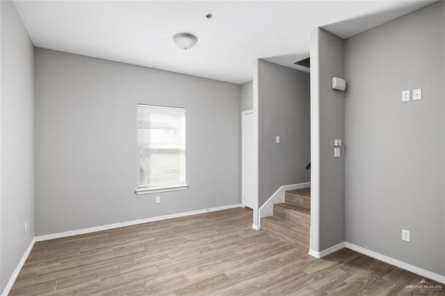 Spare room featuring wood finished floors and stairway | Image 6