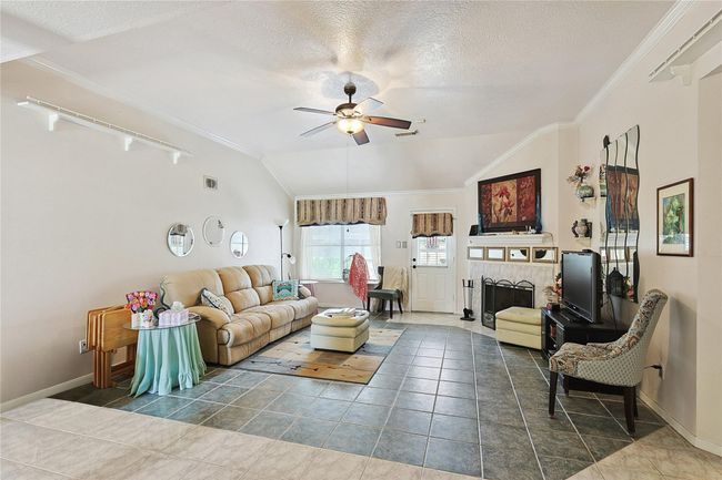 Living room thoughtfully designed with decorative tile accents that define the space. No carpet — easy to maintain floors with timeless charm. | Image 12