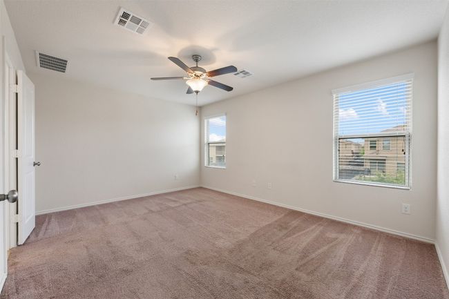Unfurnished room with light colored carpet, ceiling fan, and baseboards | Image 24
