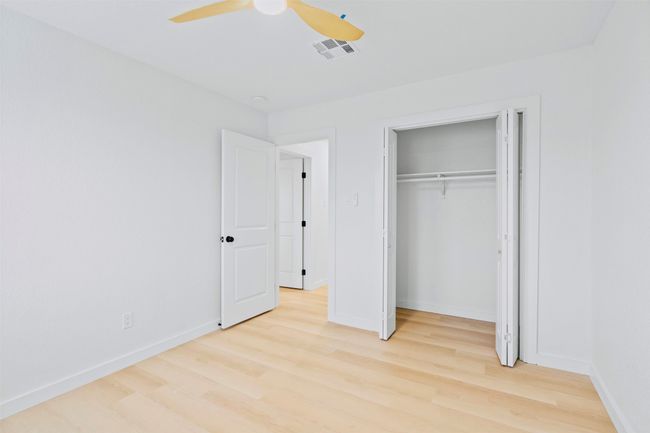 Unfurnished bedroom with light wood finished floors, ceiling fan, and a closet | Image 26