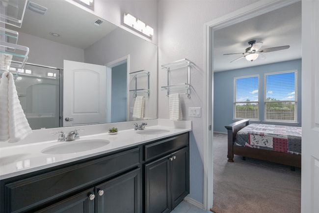 Bathroom with a shower, a ceiling fan, a sink, and double vanity | Image 18
