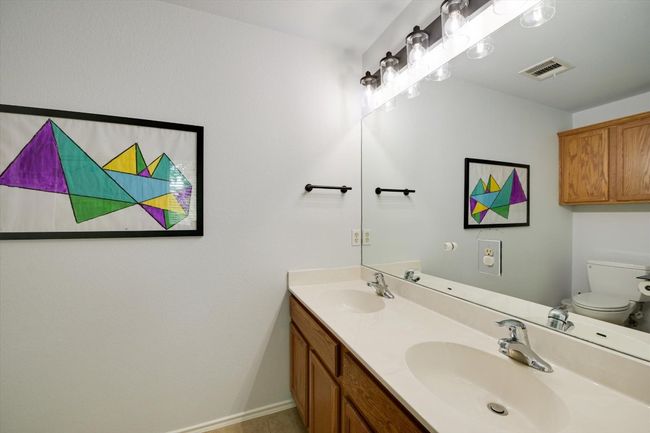Bathroom featuring toilet and double vanity | Image 14
