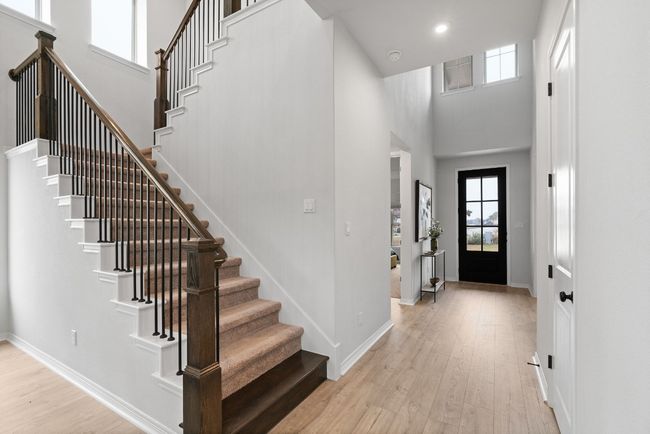 A bright entrance foyer with a chic front door and an open and airy entryway. | Image 4