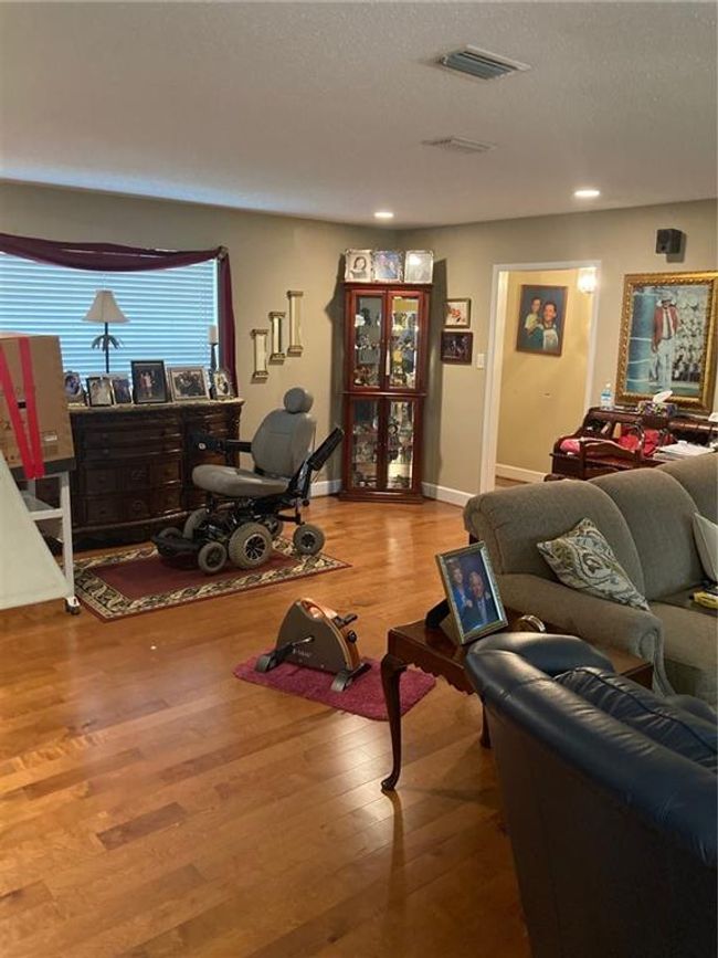 Living room with wood-type flooring and a textured ceiling | Image 10