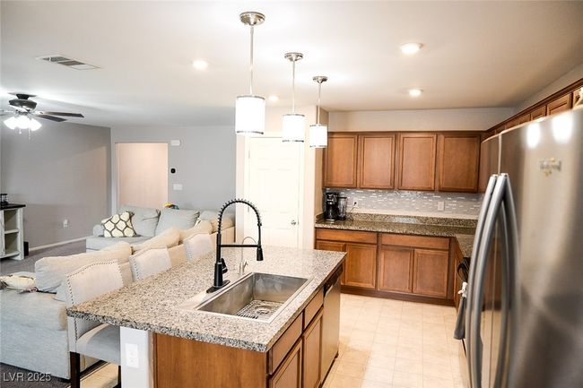 Kitchen with brown cabinets, stainless steel appliances, and a sink | Image 10