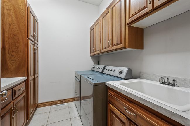 Main level laundry with ceramic tile flooring & plenty of storage to keep you organized. Enjoy one level living with all main amenities located on the main floor. | Image 24