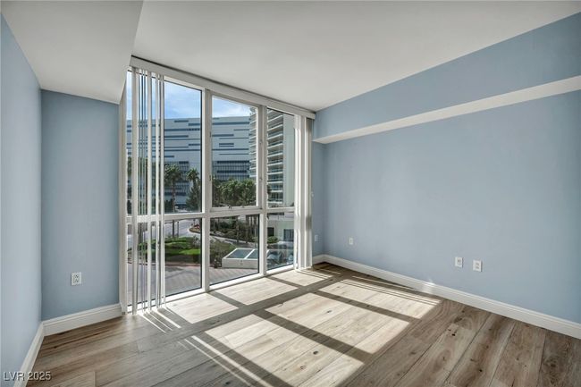 Unfurnished room with wood finished floors, expansive windows, and baseboards | Image 12
