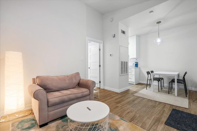 Living area with wood finished floors and a high ceiling | Image 7