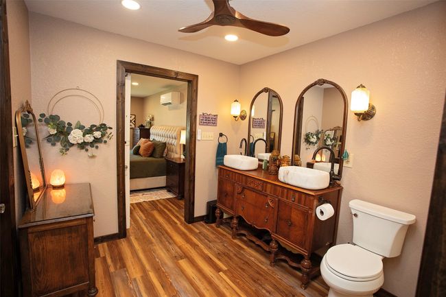 Bathroom with ensuite bath, wood finished floors, a wall unit AC, ceiling fan, and double vanity | Image 38