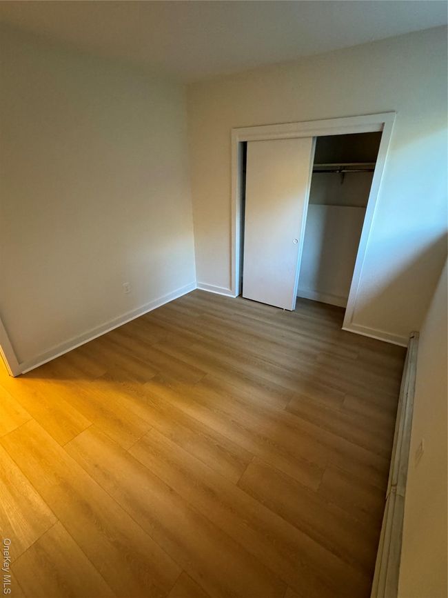 Unfurnished bedroom featuring wood finished floors and a closet | Image 7