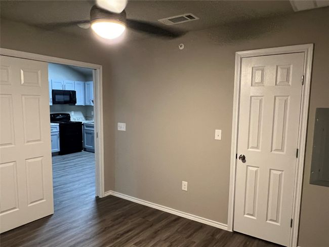Spare room with dark wood-style flooring, a ceiling fan, baseboards, and electric panel | Image 6