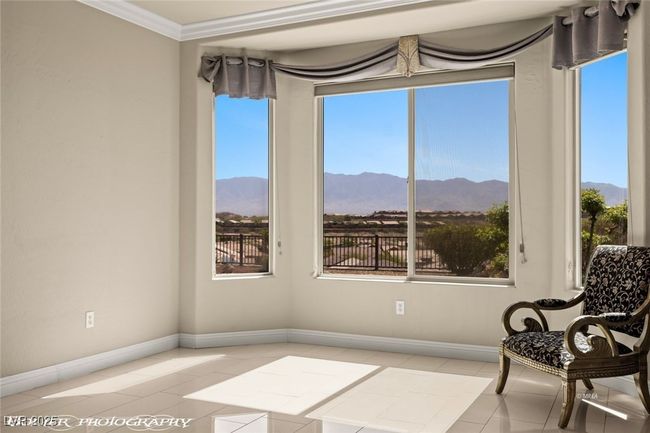 Sitting room with tile patterned floors, baseboards, a mountain view, and a healthy amount of sunlight | Image 42