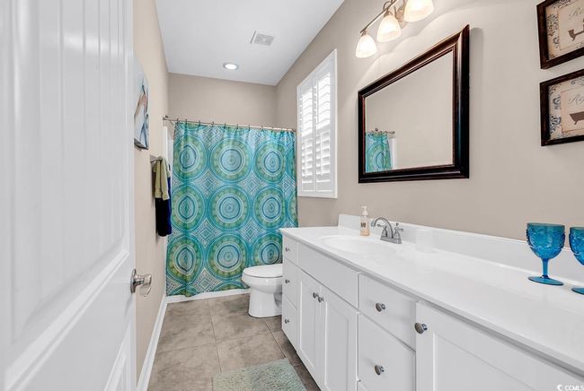 Half bath with tile patterned floors, toilet, baseboards, and vanity | Image 27