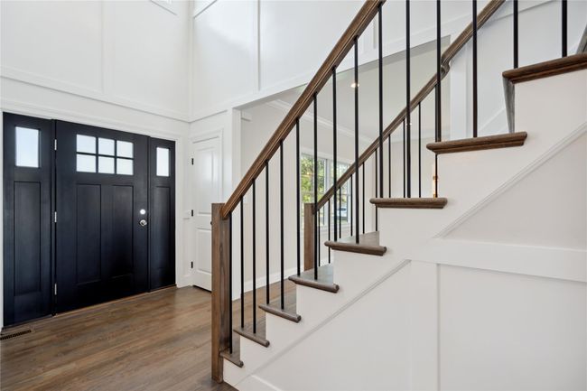 Entryway with a high ceiling, stairway, and wood finished floors | Image 4