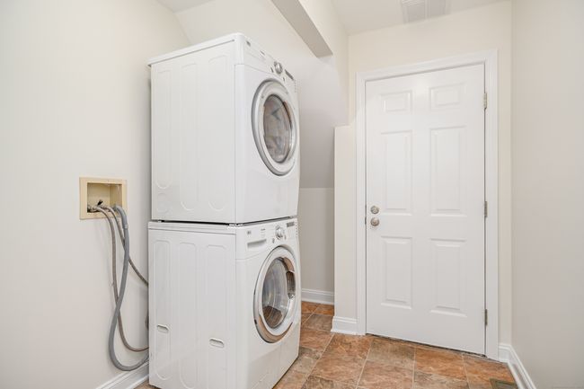 Laundry room situated between the kitchen and the garage. | Image 17