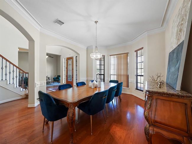 Elegant dining room with classic charm, featuring hardwood floors and a sparkling chandelier—perfect for hosting memorable gatherings. | Image 11