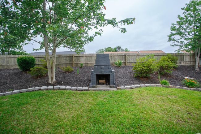 View of yard with an outdoor stone fireplace | Image 15