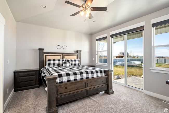 Bedroom with lofted ceiling, baseboards, carpet flooring, access to exterior, and ceiling fan | Image 17