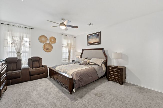 Bedroom featuring light colored carpet and ceiling fan | Image 17
