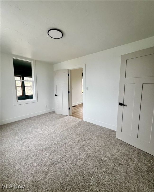 Unfurnished bedroom featuring baseboards and carpet | Image 15