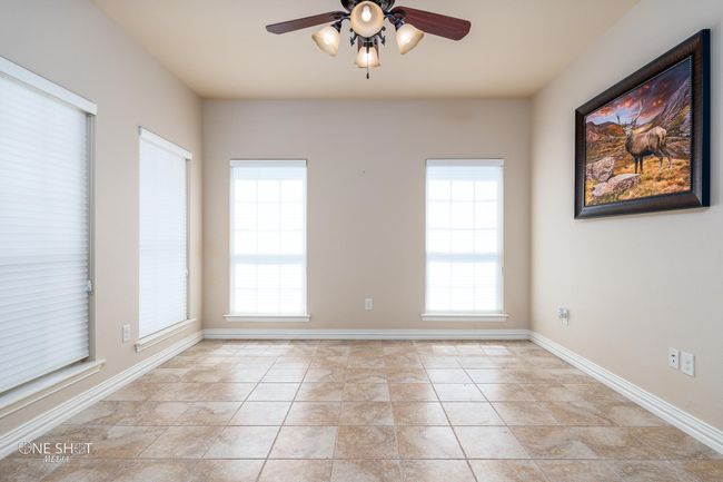 Spare room featuring a ceiling fan, plenty of natural light, baseboards, and light tile patterned floors | Image 35