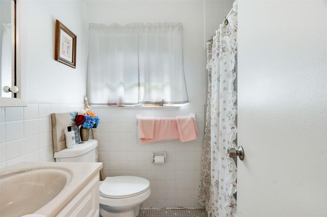 Bathroom featuring tile walls, vanity, and a shower with shower curtain | Image 15