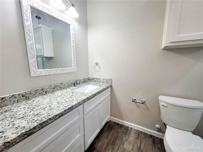 Bathroom featuring toilet, vanity, wood finished floors, and baseboards | Image 9