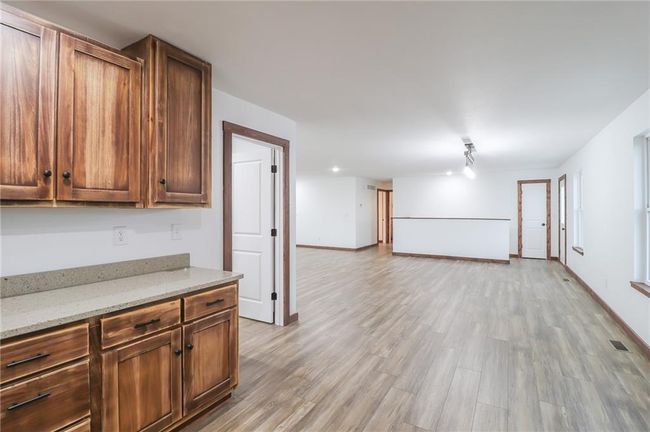 Kitchen with light stone counters and light wood-type flooring | Image 16