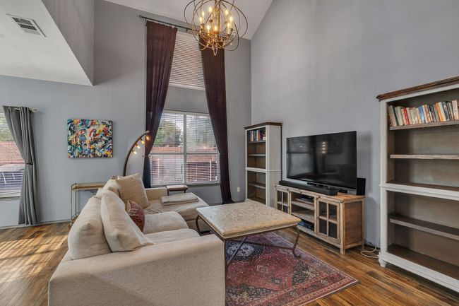 Living room with high vaulted ceiling, a chandelier, and wood finished floors | Image 16