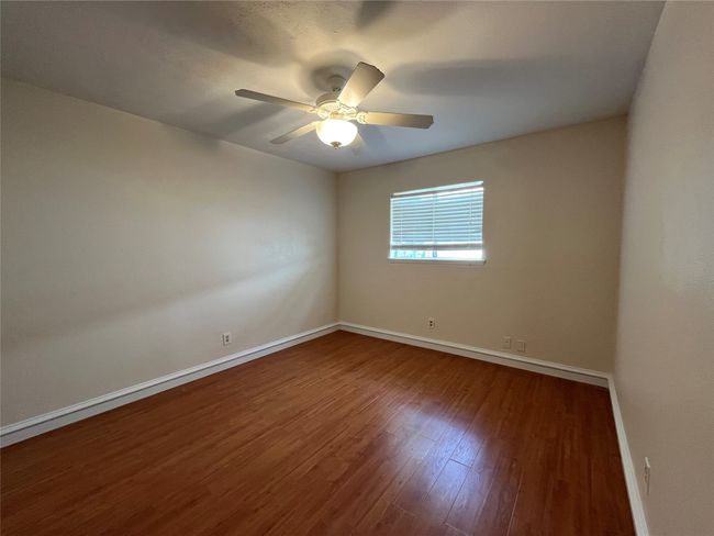 Spare room featuring wood finished floors, baseboards, and ceiling fan | Image 21