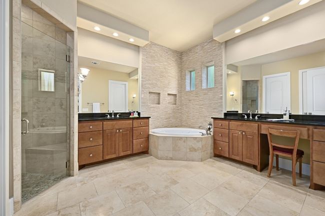 Bathroom with a recessed shower, two vanities, recessed lighting, and a separate bath | Image 13
