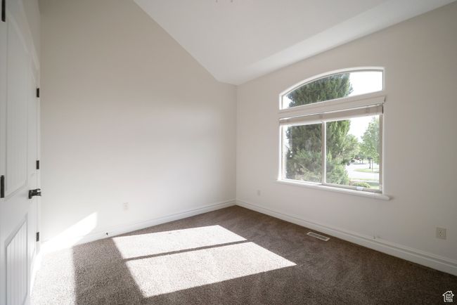 Carpeted spare room with baseboards, visible vents, and lofted ceiling | Image 20