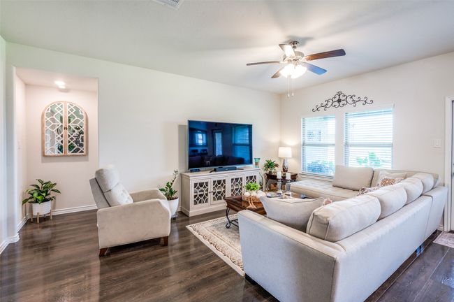 Living area featuring a ceiling fan and dark wood-style floors | Image 7