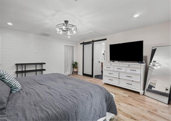 Alternate angle showing barn door entry to the bath and generous furniture space. | Image 27