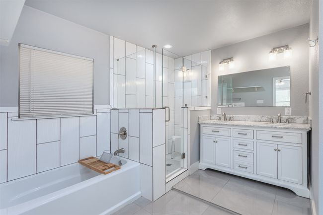 Bathroom featuring a shower stall, a garden tub, a sink, and double vanity | Image 15