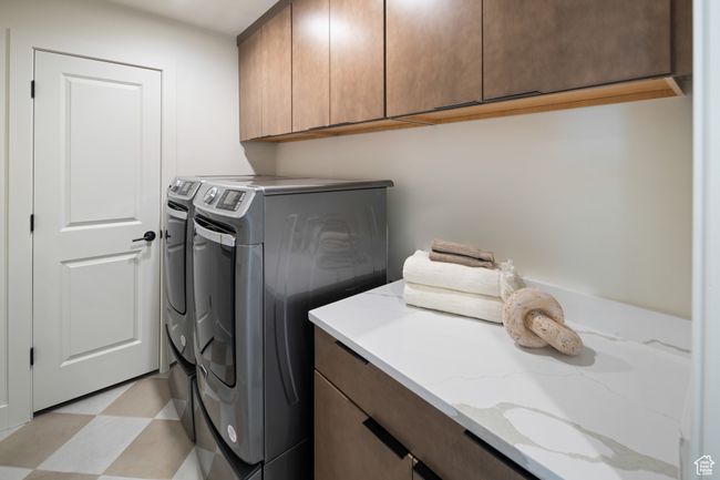 Clothes washing area featuring cabinet space, washer and clothes dryer, and light floors | Image 23