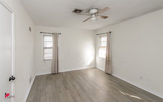 Empty room featuring visible vents, baseboards, ornamental molding, a ceiling fan, and light wood-style floors | Image 7