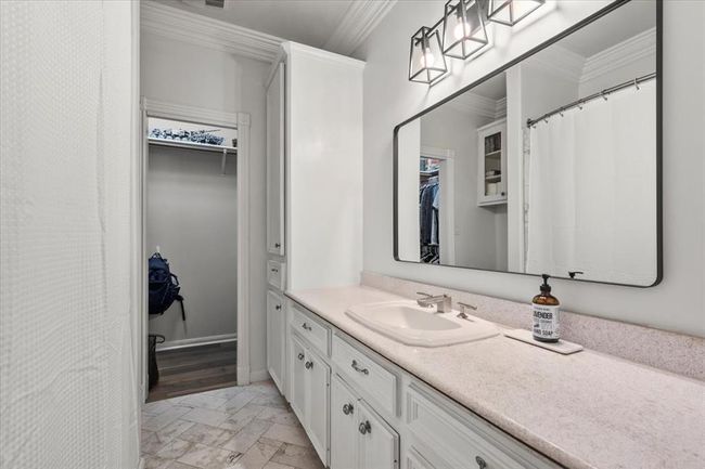 A third full bathroom continues the classic style with wide mirrors, dual vanities, and a large walk-in closet. | Image 31