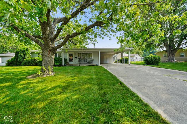 ranch-style house with concrete driveway, a carport, and covered porch | Image 5
