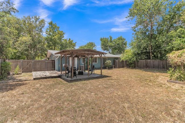 Fenced backyard featuring a wooden deck and a pergola | Image 13
