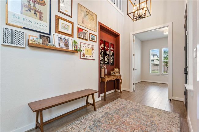 Foyer featuring wood finished floors, a notable chandelier, and baseboards | Image 5