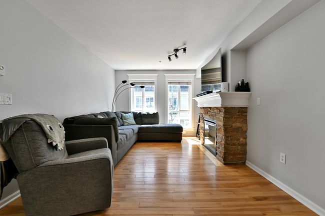 Living area featuring light wood-style flooring, baseboards, and a fireplace | Image 6