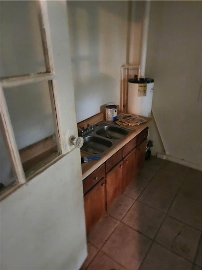 Kitchen with sink and light tile patterned floors | Image 7