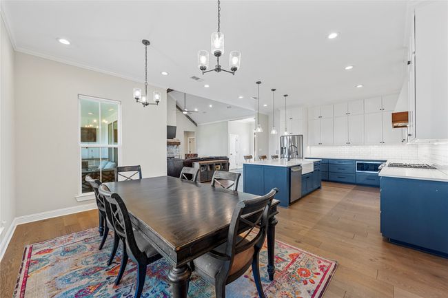 Dining space with crown molding, recessed lighting, light wood finished floors, a notable chandelier, and baseboards | Image 11